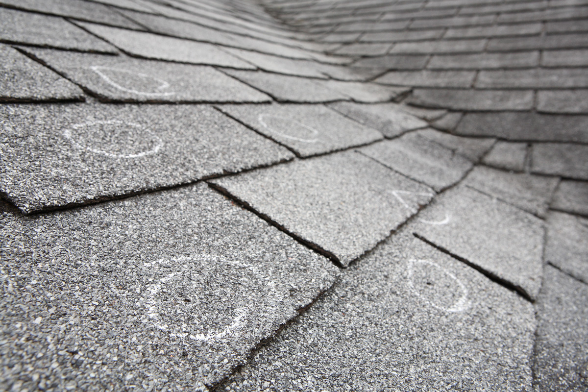 Shingles with white circles to indicate hail damage spots in El Paso.