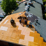 An aerial view of multiple people replacing a roof in El Paso.