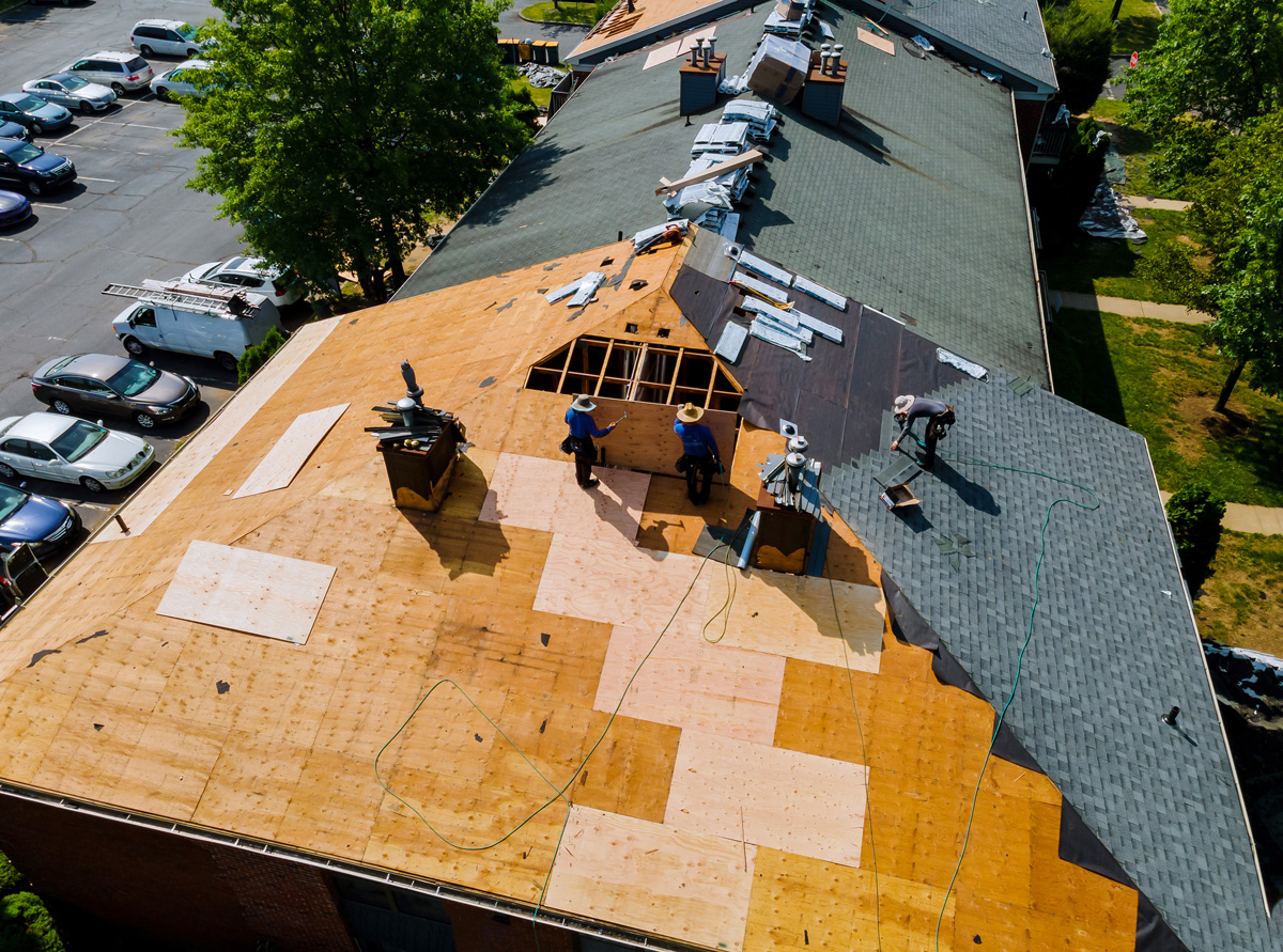 An aerial view of multiple people replacing a roof in El Paso.