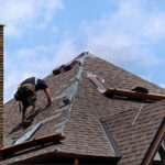 A person on a home’s roof performing roof repair in El Paso.