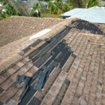 A hail-damaged roof with shingles missing in El Paso.