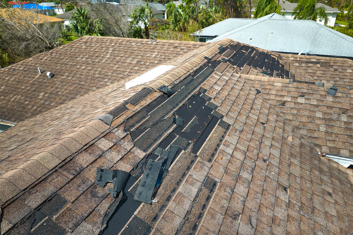 A hail-damaged roof with shingles missing in El Paso.